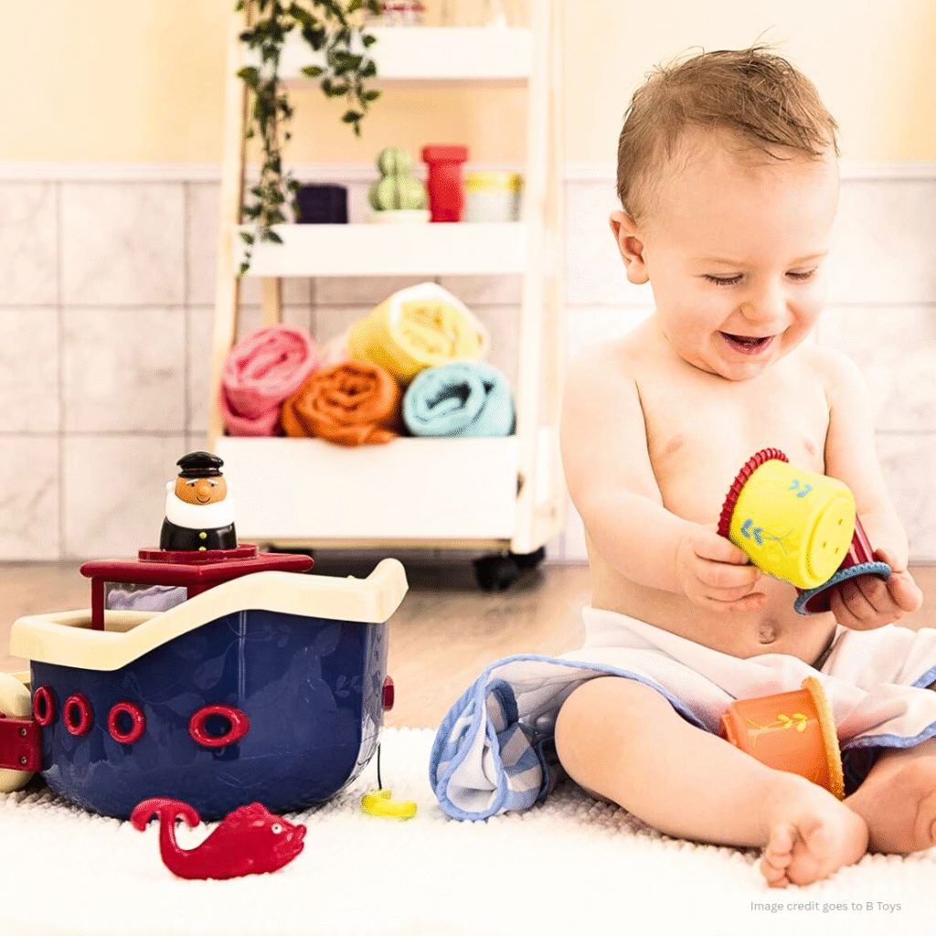 Image of a baby and some toys along with him/her. In the bottom area of the image a text is visible - ' image credit goes to B'.